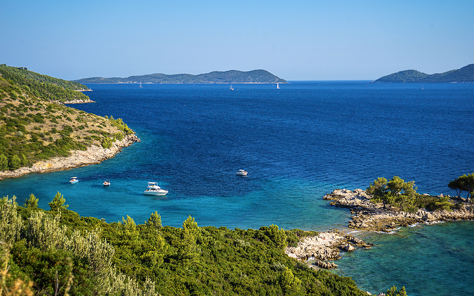 Aerial view of Kolocep Island coastline with boats in the Adriatic Sea, Croatia.