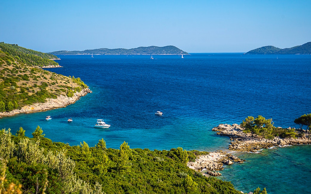 Aerial view of Kolocep Island coastline with boats in the Adriatic Sea, Croatia.