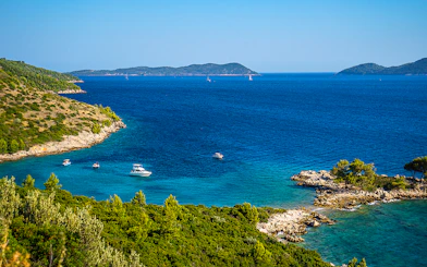 Aerial view of Kolocep Island coastline with boats in the Adriatic Sea, Croatia.