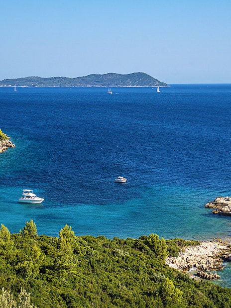 Aerial view of Kolocep Island coastline with boats in the Adriatic Sea, Croatia.
