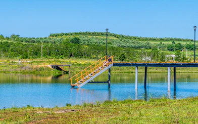 Staircase leading to a pier over the lake at Belsh lakes, surrounded by greenery.
