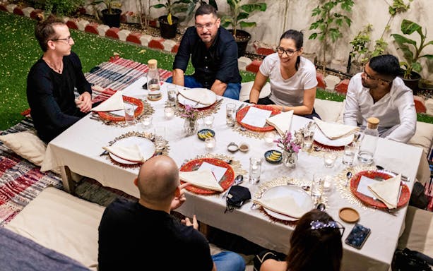 Guests seated around a table at Chef Kuv's Secret Supper, enjoying an underground dining experience.