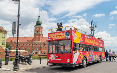 Warsaw hop-on hop-off bus near Royal Castle on a sunny day.