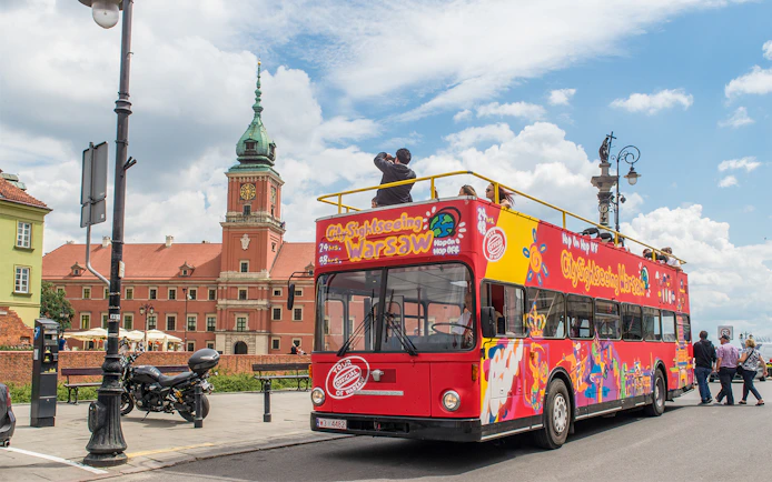 Warsaw hop-on hop-off bus near Royal Castle on a sunny day.