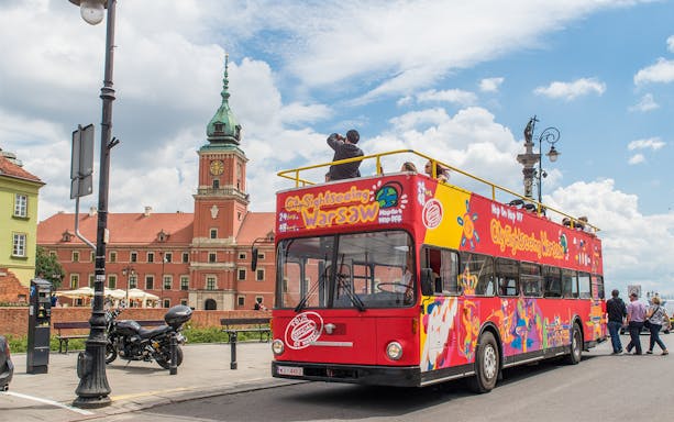Warsaw hop-on hop-off bus near Royal Castle on a sunny day.