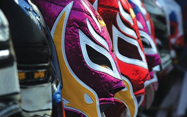 Colorful lucha libre masks lined up for a Mexico City wrestling tour.