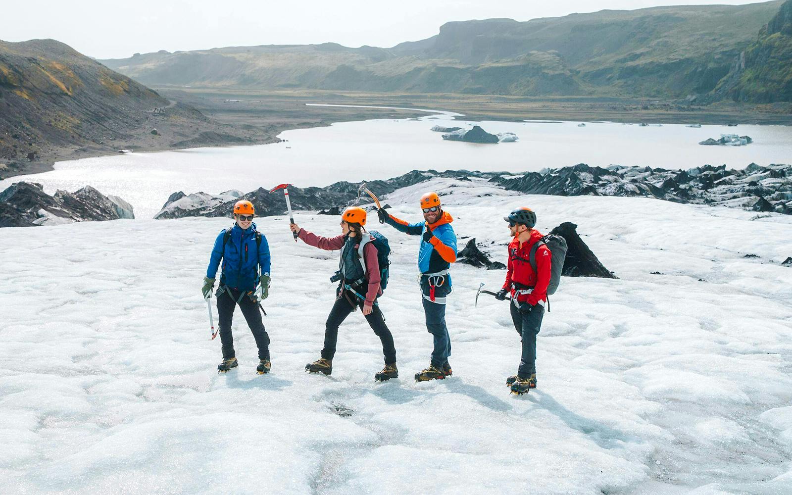 Guests hiking on Solheimajökill Glacier with ice axes and helmets in Iceland.