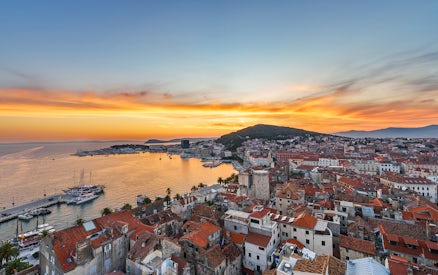 Sunset view of Split Riviera with boats docked, highlighting the coastal cityscape.