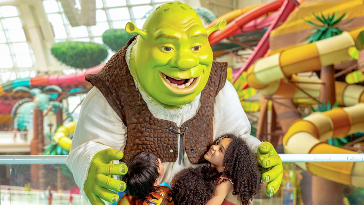 Kids hugging a character at Forbidden Waters Pool, American Dream DreamWorks Water Park.