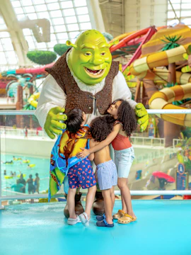 Kids hugging a character at Forbidden Waters Pool, American Dream DreamWorks Water Park.