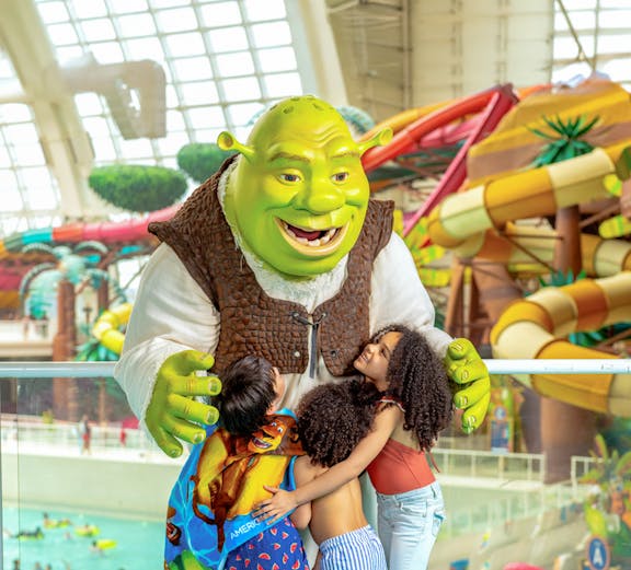 Kids hugging a character at Forbidden Waters Pool, American Dream DreamWorks Water Park.