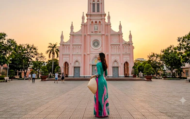 Woman in traditional dress at Da Nang Cathedral during sunset.