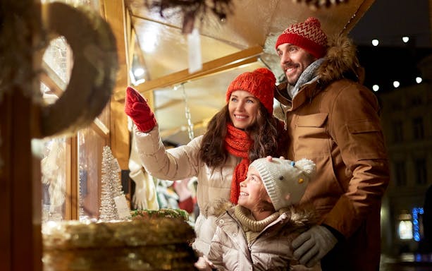 Family exploring Christmas market on Big Bus New York Holiday Lights Tour.