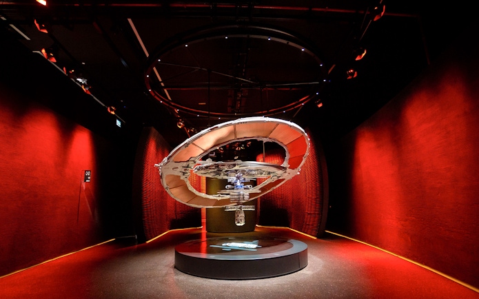 Futuristic exhibit in red-lit room at Museum of The Future, Dubai.
