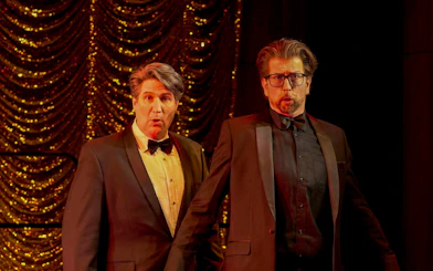 Two actors in tuxedos performing on stage during My Fair Lady musical.