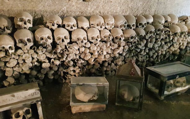 Skulls and bones stacked in Fontanelle Cemetery, Naples, part of Rione Sanità walking tour.
