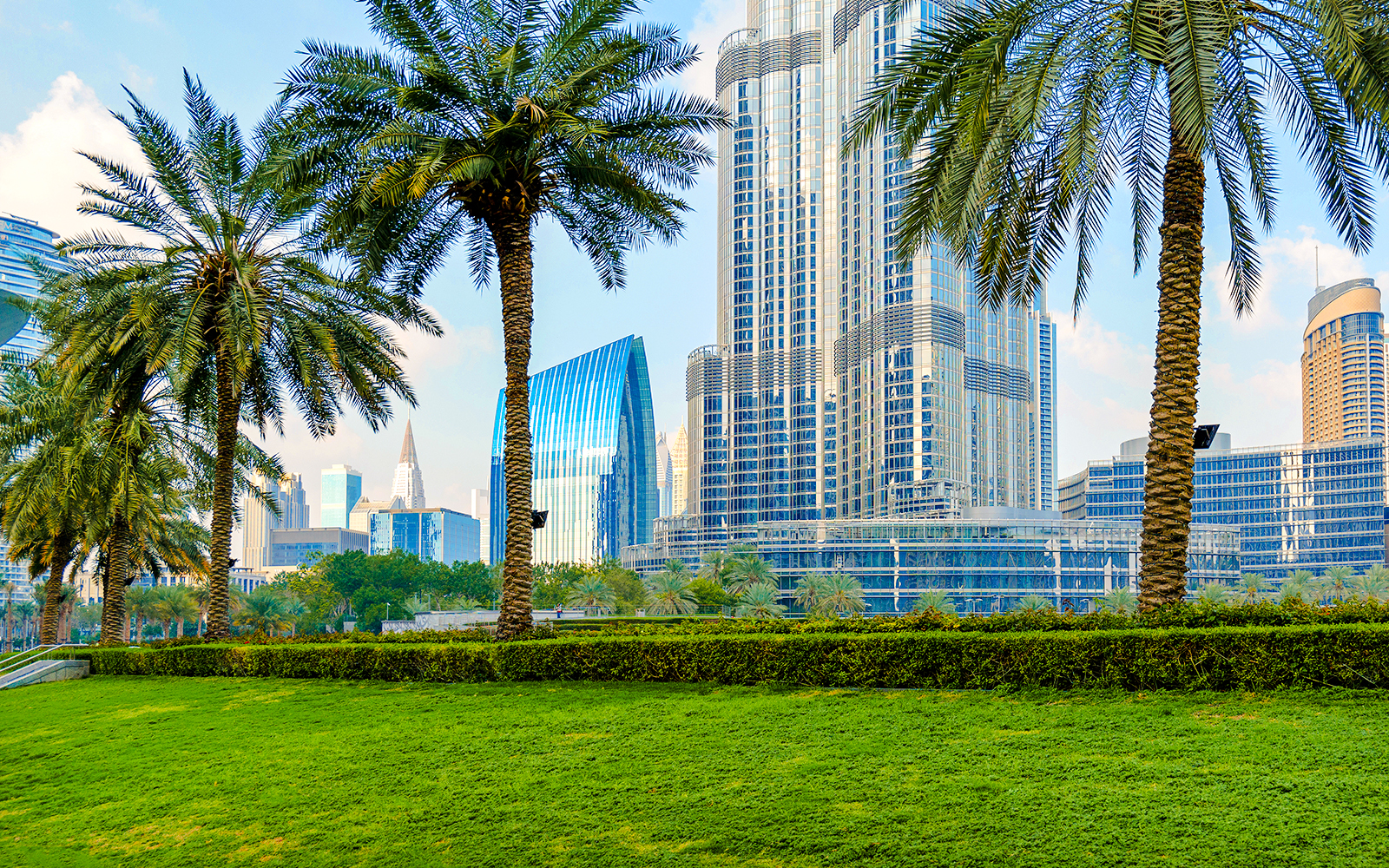 Burj Park in Dubai with palm trees and city skyline in the background.