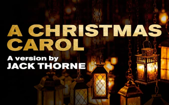 A Christmas Carol West End show poster with lanterns in the background.