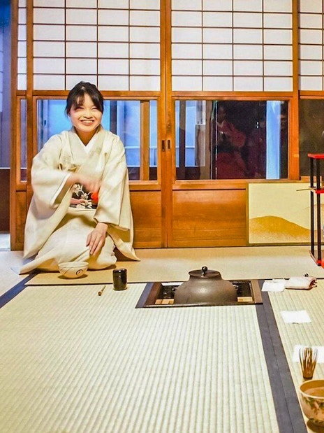 Participants in traditional attire at a Japanese tea ceremony, learning matcha-making techniques.