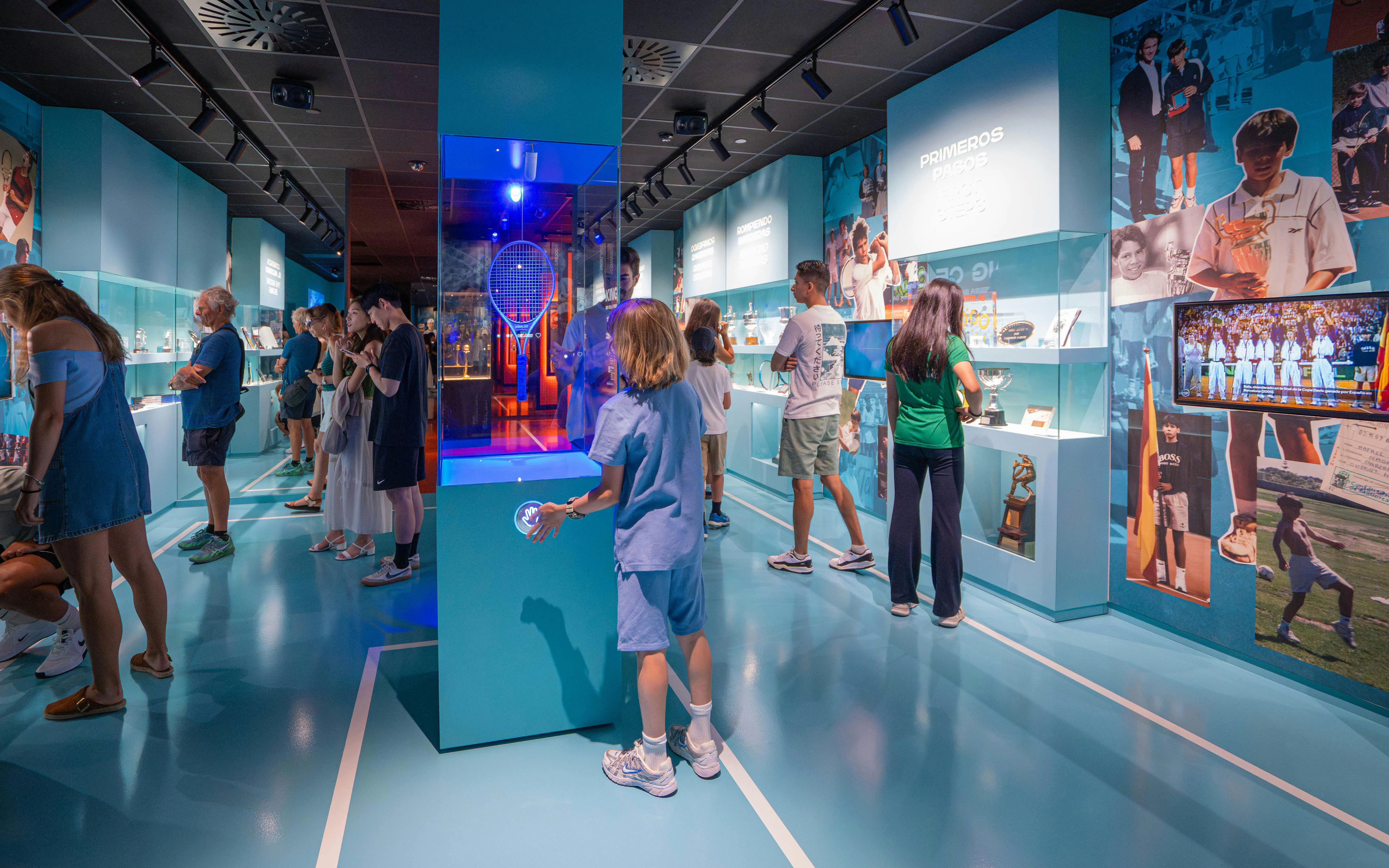 Visitors exploring exhibits at Rafa Nadal Museum, featuring tennis memorabilia and interactive displays.