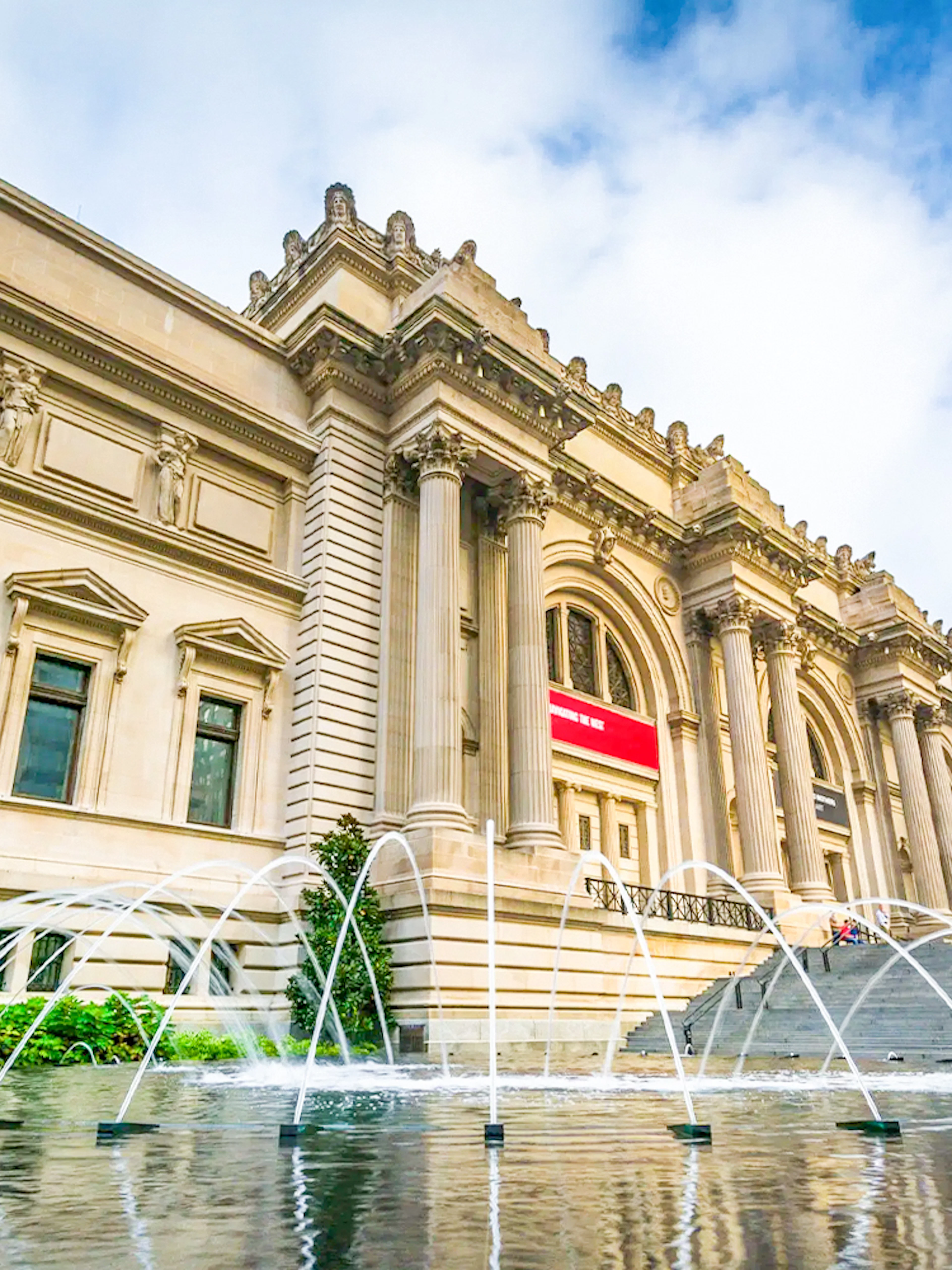 The Met Museum entrance with fountain and steps, New York City.