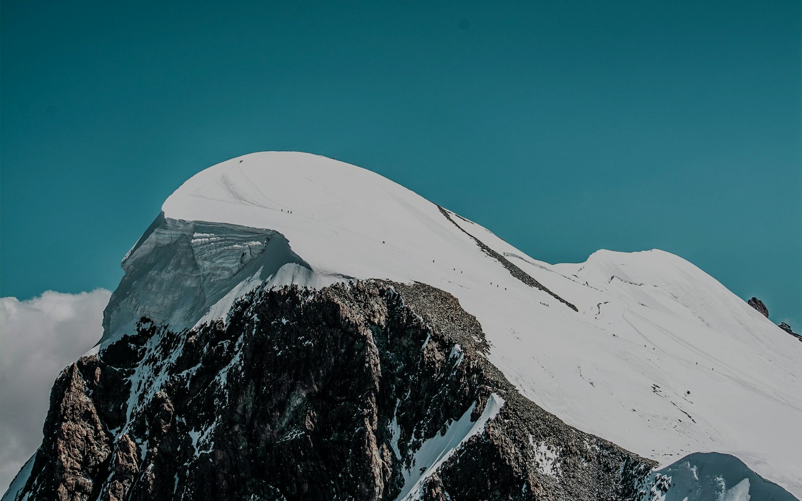 Gornergrat Railway train traveling through snowy Alps with view of Klein Matterhorn in Switzerland.