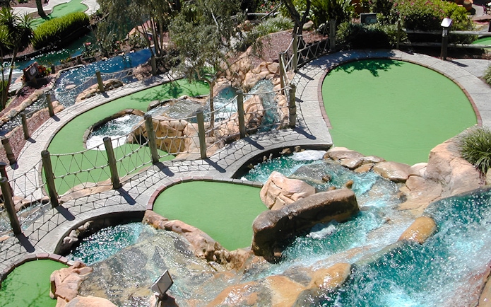 Mini-golf course with waterfalls and bridges at Pirate's Cove Adventure Golf.
