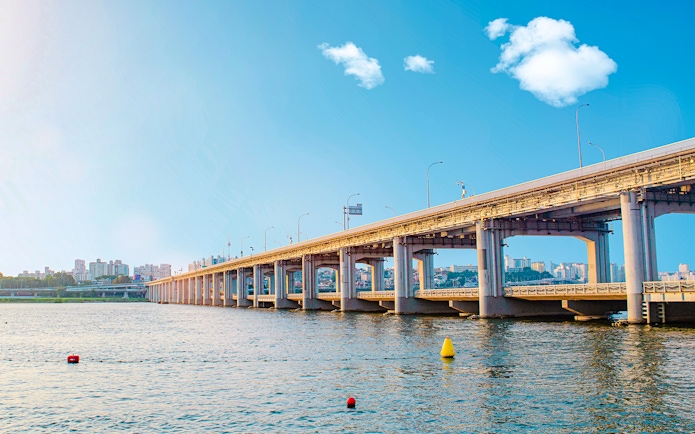 Banpo Bridge spanning the Han River in Seoul, with city skyline in the background.