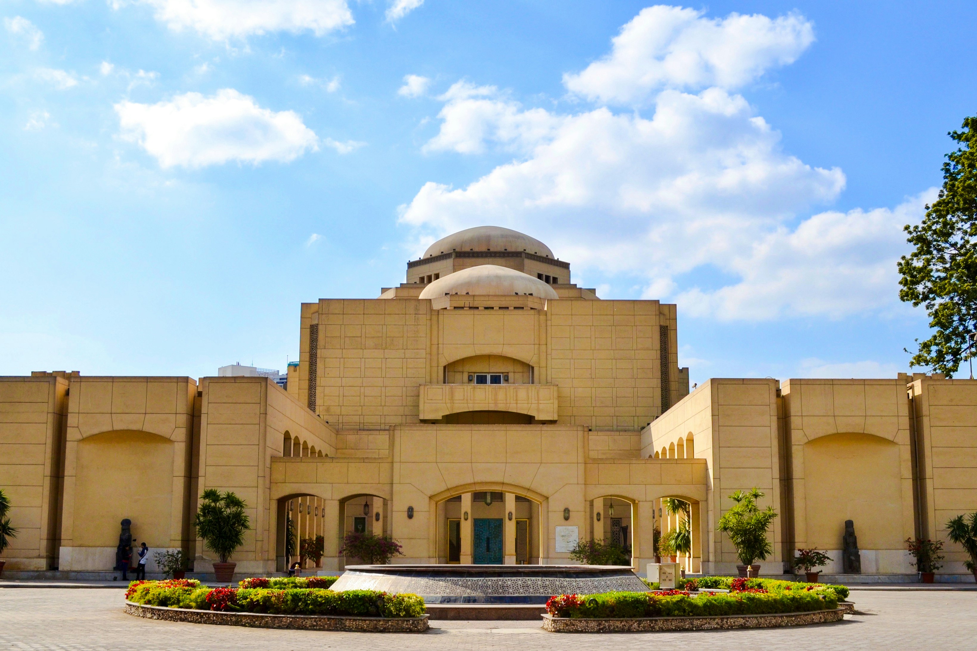 Cairo Opera House exterior with clear blue sky and surrounding gardens.