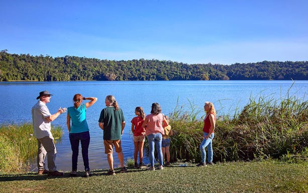 Group observing lake and rainforest during a nocturnal wildlife tour.