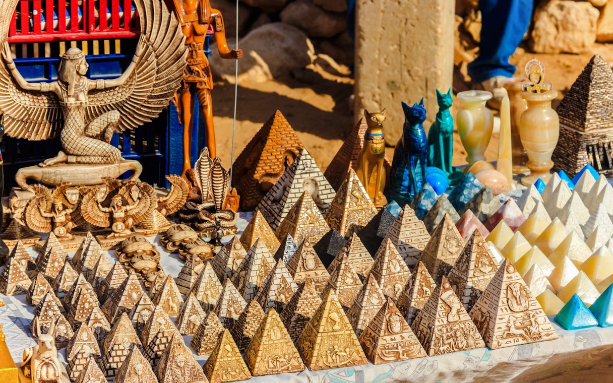 Traditional Egyptian souvenirs at Old Bazaar in Cairo, featuring pyramid replicas and statues.