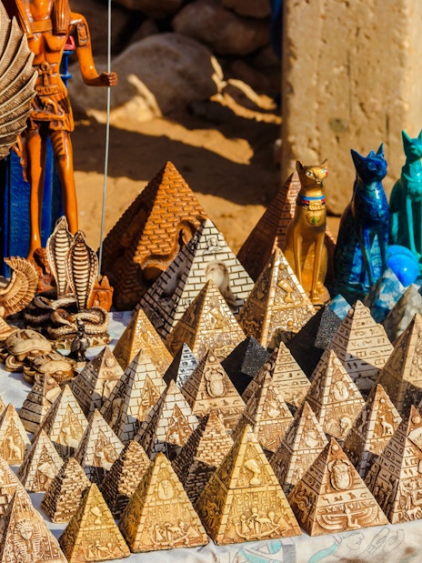 Traditional Egyptian souvenirs at Old Bazaar in Cairo, featuring pyramid replicas and statues.