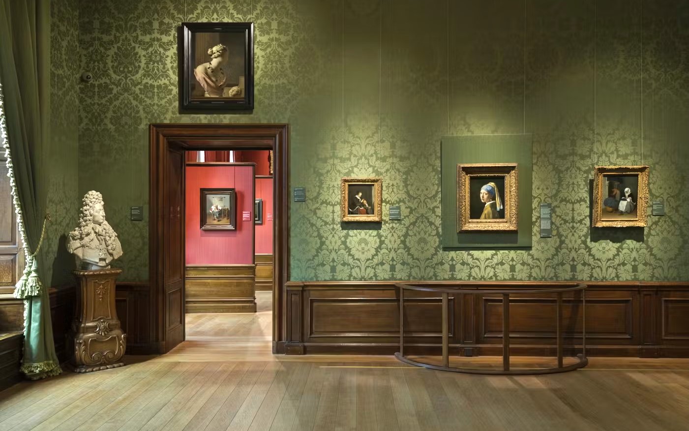 Mauritshuis museum gallery with classic paintings and a marble bust.