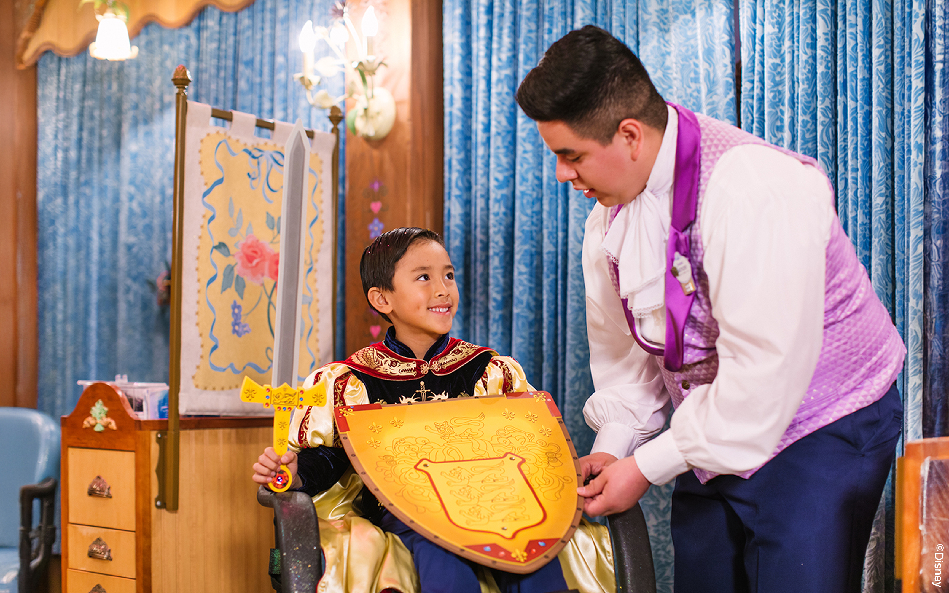 Child in knight costume holding shield at Disneyland Park, California.