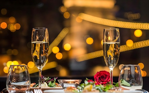 Champagne glasses and rose on table during Valentine's Day dinner cruise.