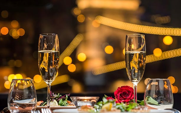 Champagne glasses and rose on table during Valentine's Day dinner cruise.