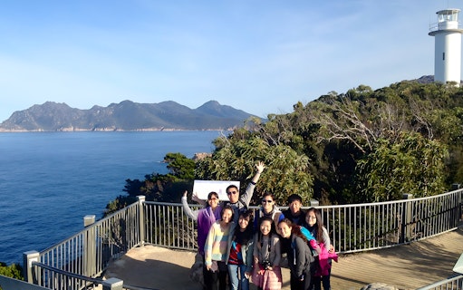 Group at Wineglass Bay lookout with ocean and mountains, Launceston to Hobart tour.