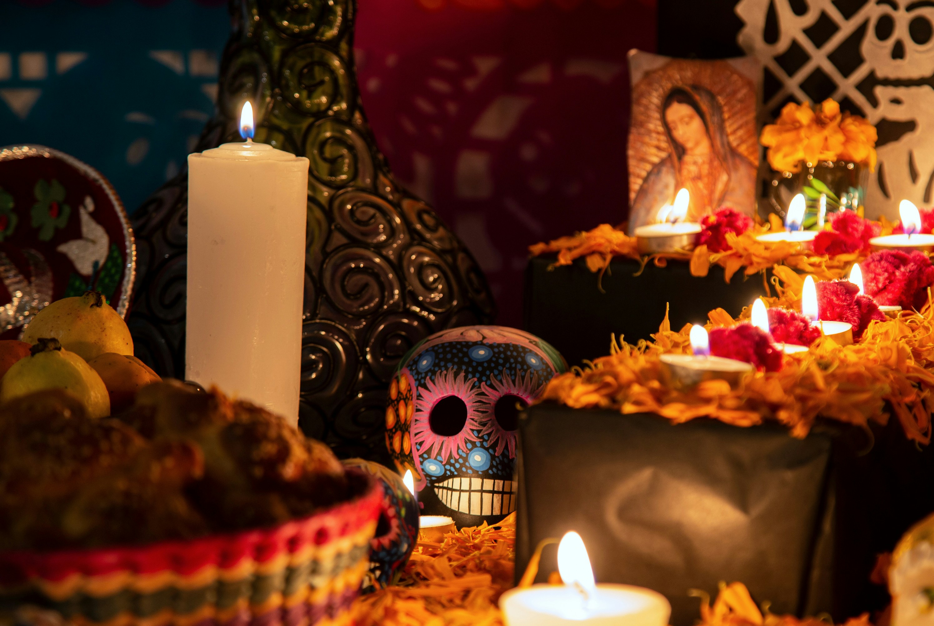 Day of the Dead ofrenda with candles, marigolds, and a decorated skull in Mexico.
