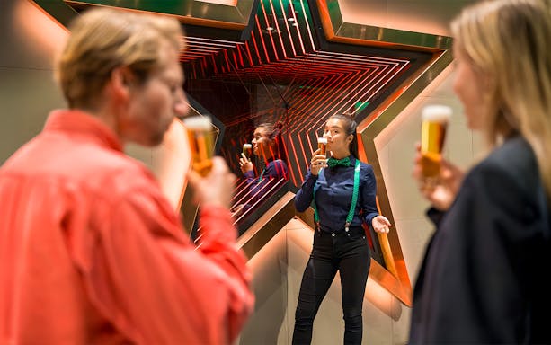 Tourists enjoying beer at Heineken Experience in Amsterdam.