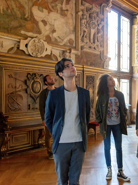 Visitors exploring ornate hall at Vaux-le-Vicomte during Paris audio-guided tour.