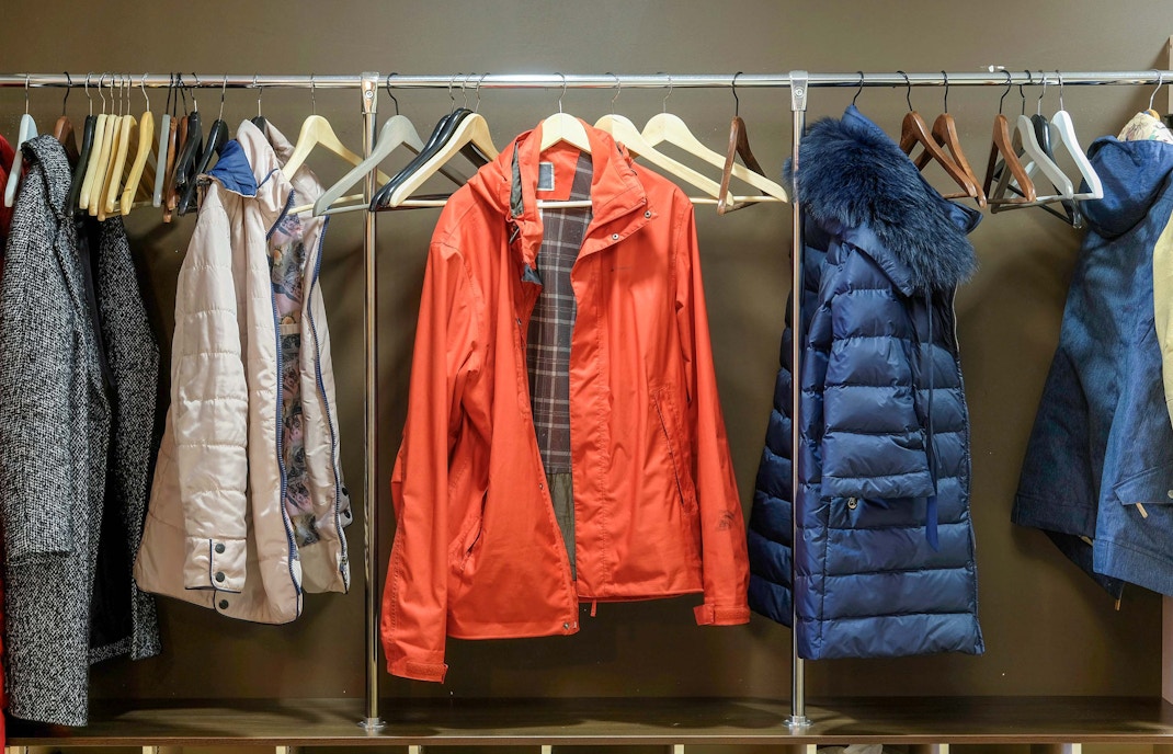 Cappotti appesi in un guardaroba su una rastrelliera metallica.
