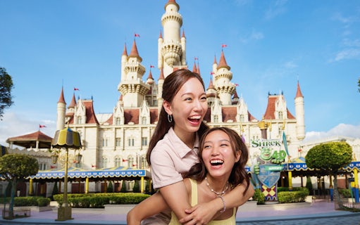 Friends enjoying at Universal Studios Singapore with castle backdrop.