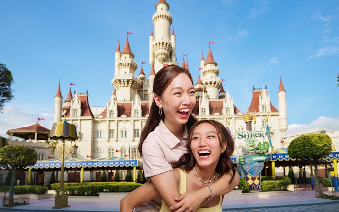 Friends enjoying at Universal Studios Singapore with castle backdrop.