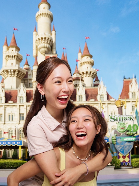 Friends enjoying at Universal Studios Singapore with castle backdrop.
