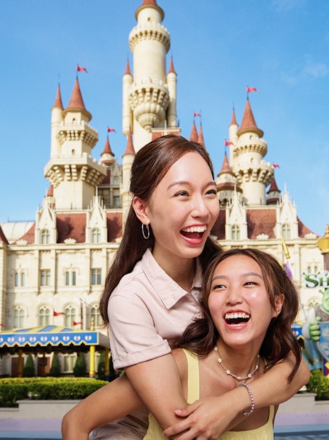Friends enjoying at Universal Studios Singapore with castle backdrop.