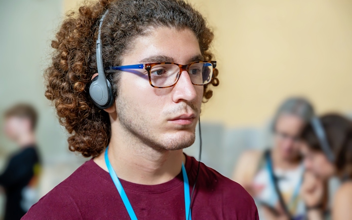 Man with headphones listening to an audio guide in a museum exhibition.