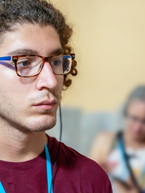 Man with headphones listening to an audio guide in a museum exhibition.