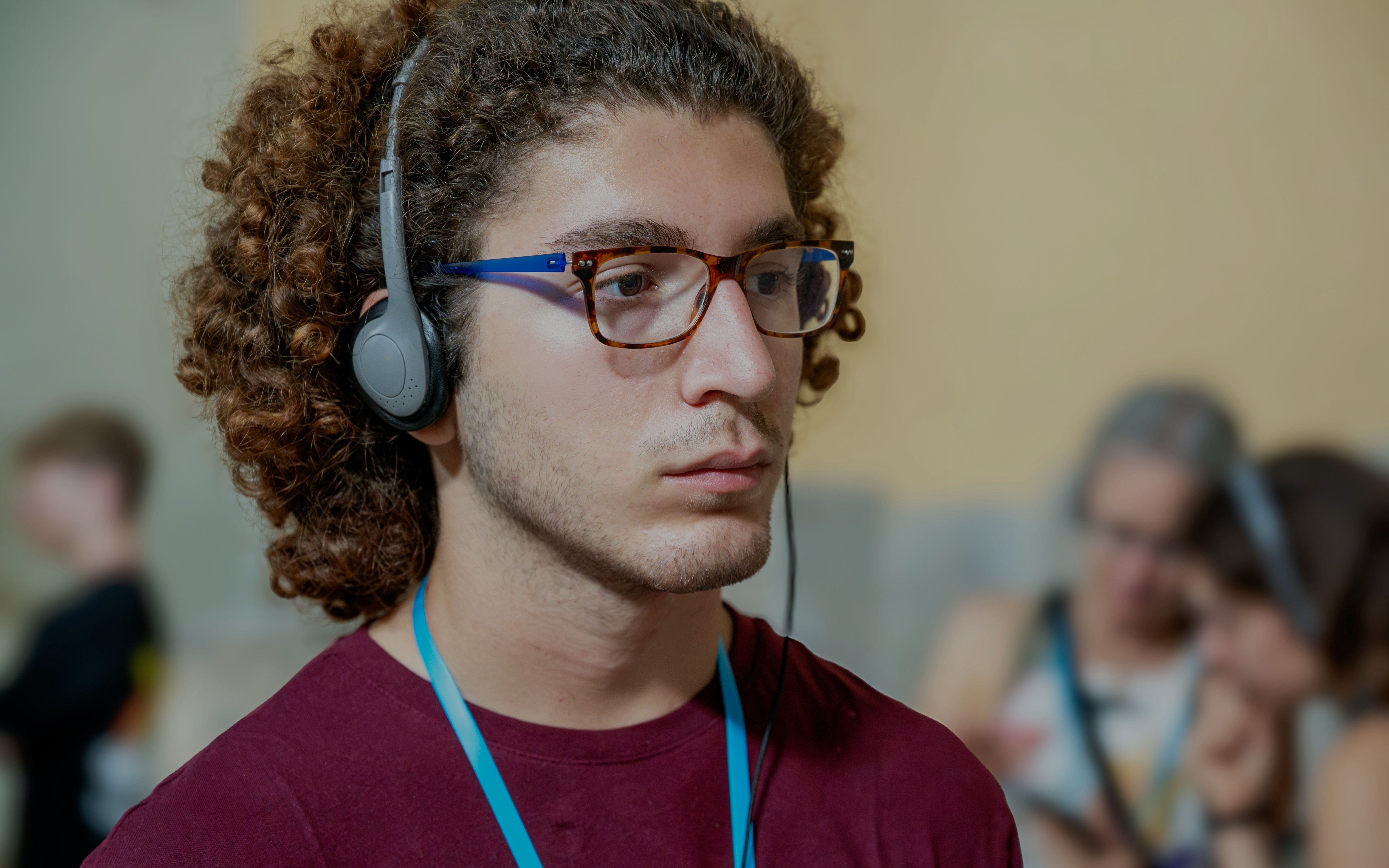 Man with headphones listening to an audio guide in a museum exhibition.