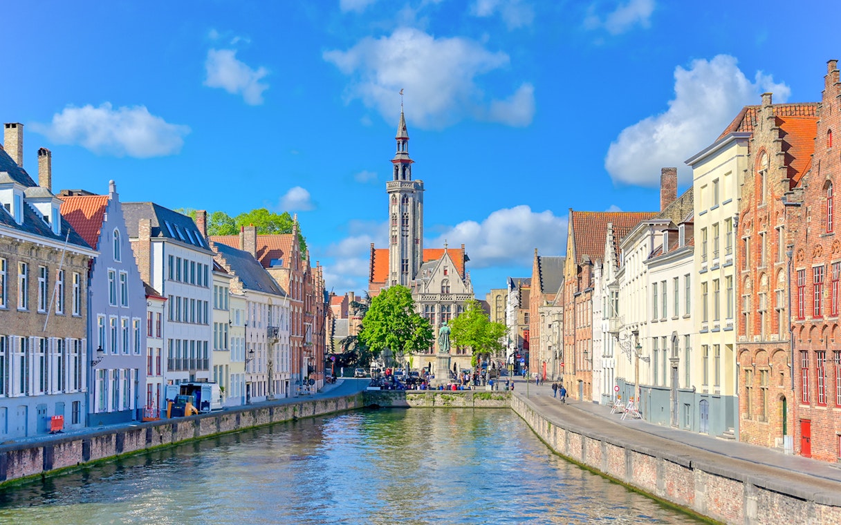 Canal view with historic buildings and Belfry of Bruges in Bruges, Belgium.
