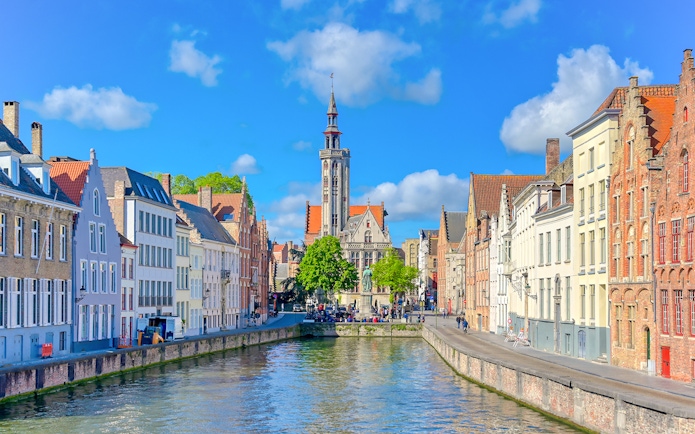 Canal view with historic buildings and Belfry of Bruges in Bruges, Belgium.